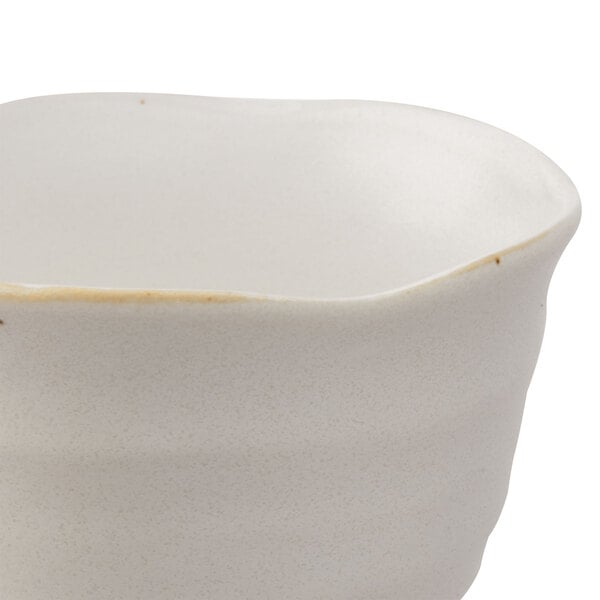 A white stoneware sake cup with a brown rim.