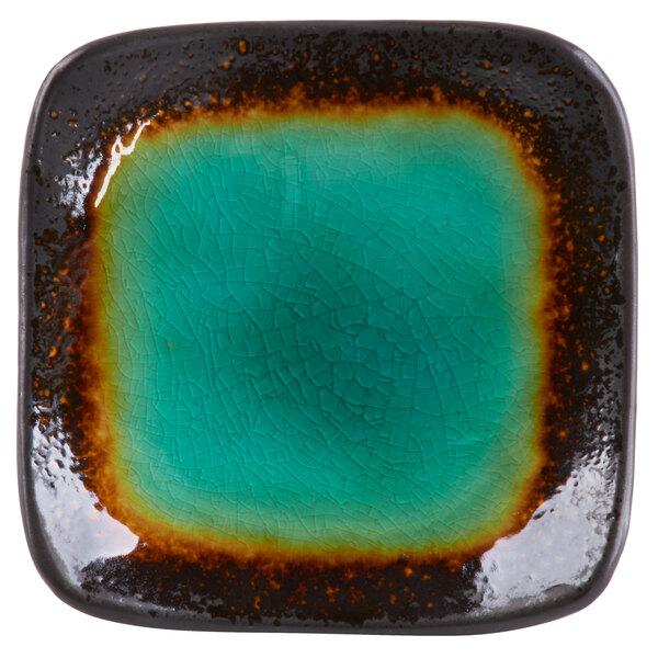 A white square stoneware dish with a blue square in the center.