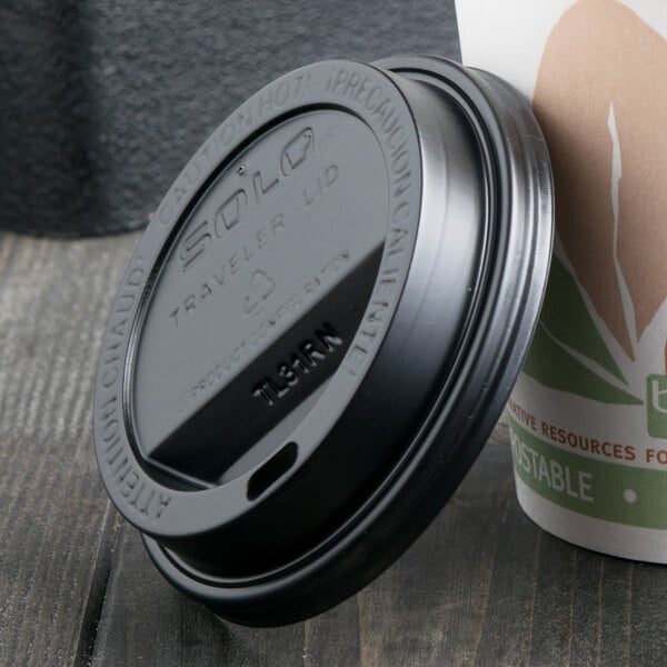 A Solo black plastic lid on a paper coffee cup.