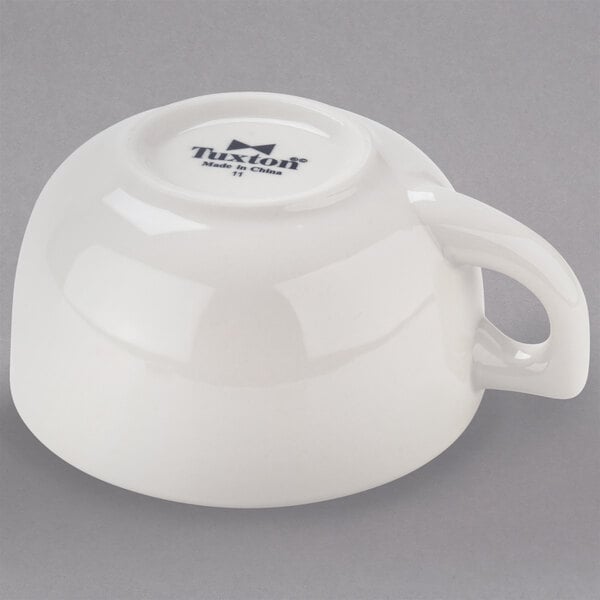 A white china cappuccino cup with a handle.