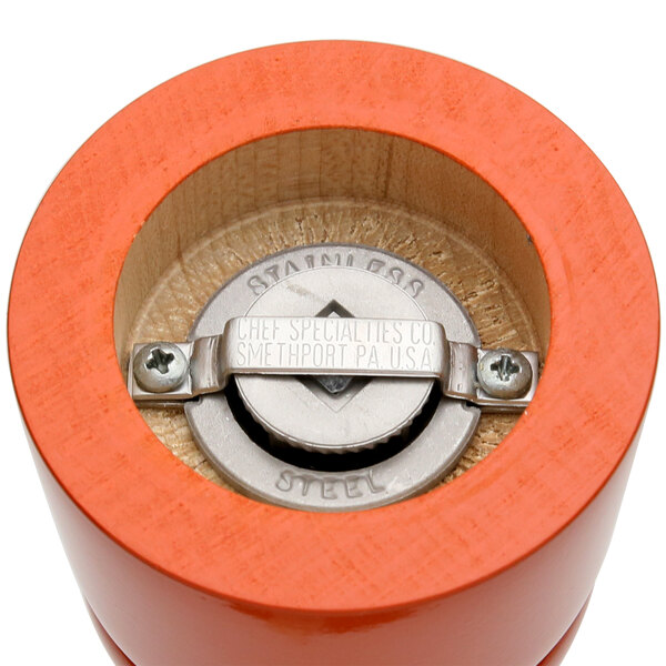 A close-up of a Chef Specialties Butternut Orange pepper mill and salt shaker with metal caps.