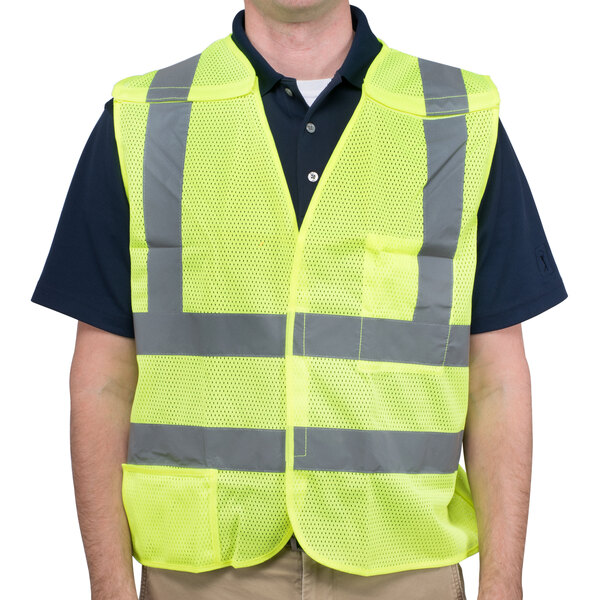 A man wearing a Cordova lime high visibility safety vest over a black shirt.