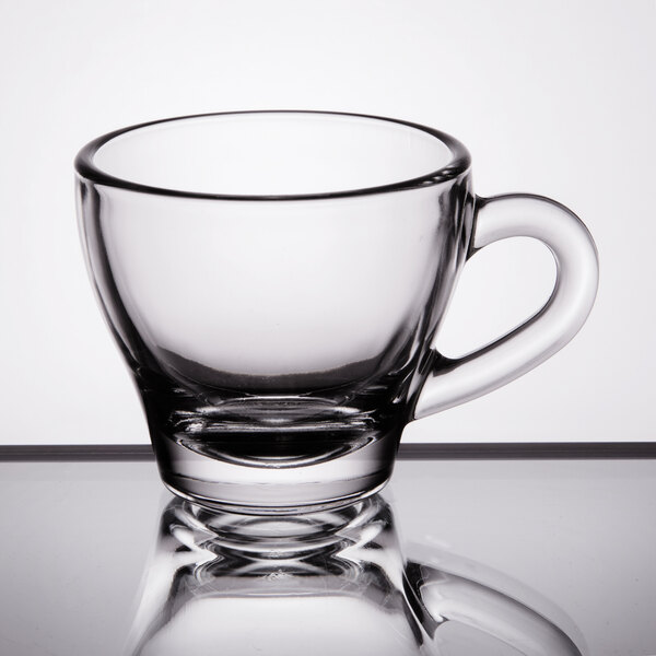 A Libbey clear glass espresso cup with handle.