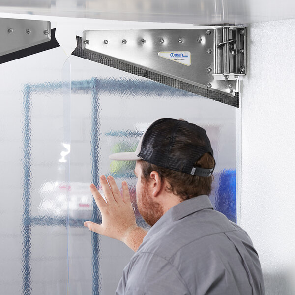 A man using a Curtron Polar-Pro swinging door in a food truck.