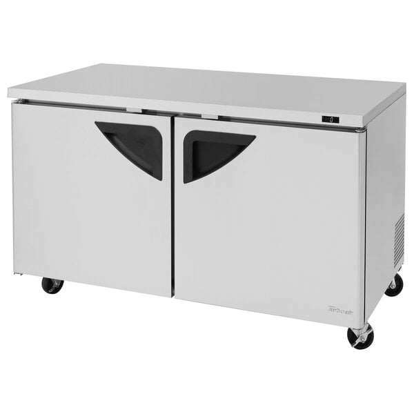 A stainless steel Turbo Air undercounter freezer with black handles.