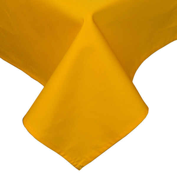 A gold rectangular tablecloth with a folded edge on a table.