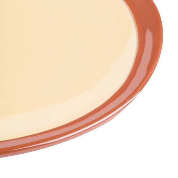 A close up of a Libbey Terracotta Mustard Seed Yellow plate with brown and orange accents.