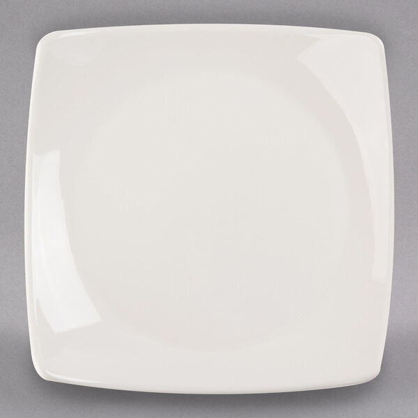 A Libbey ivory porcelain coupe plate with a white rim on a gray surface.