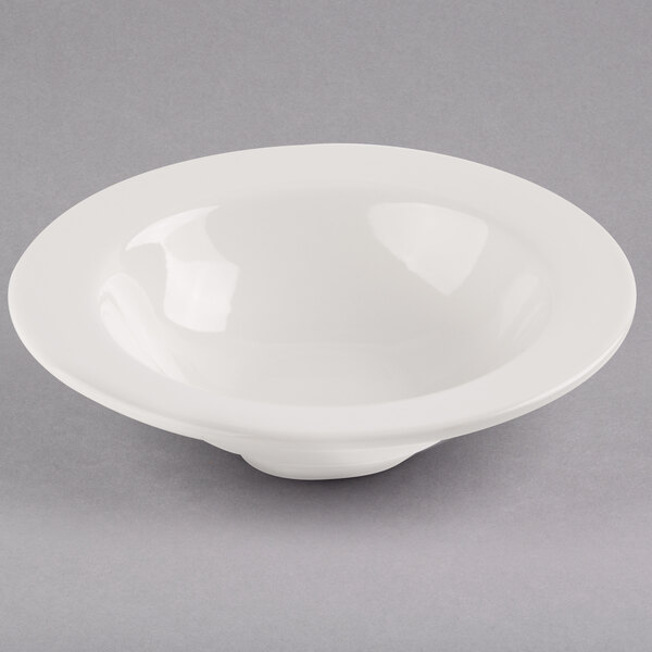 A Libbey ivory porcelain grapefruit bowl on a gray surface.
