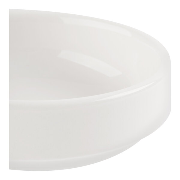 A close-up view of a round, glossy white ceramic or porcelain dish with smooth edges.