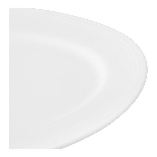 A close up of a white Libbey Aluma White medium rim porcelain platter with a curved edge.