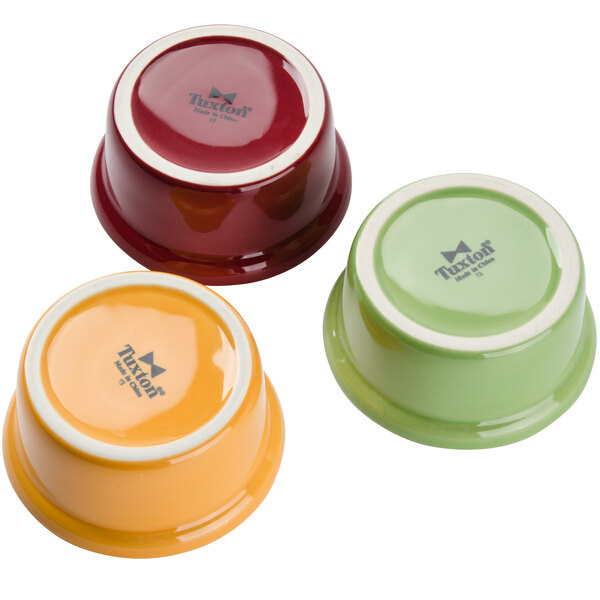 A close-up of three Tuxton casserole bowls in assorted colors.