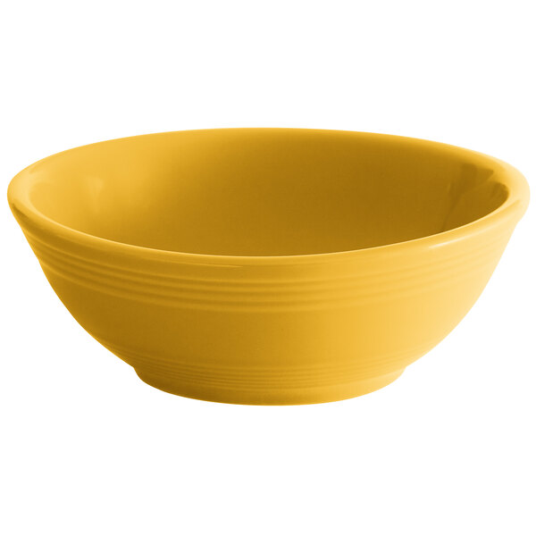 A yellow bowl with a white rim on a white background.