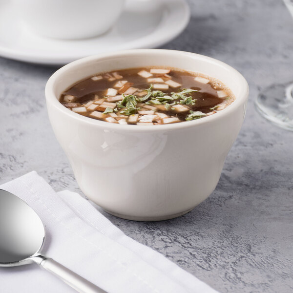 A bowl of soup in a Libbey St. Francis bouillon cup with a spoon.