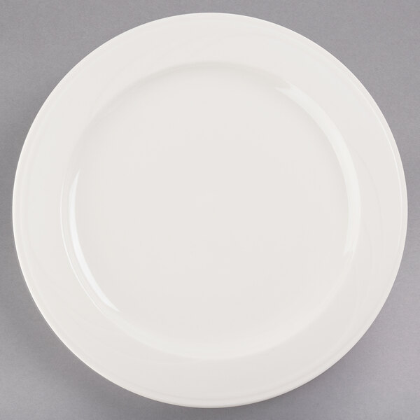 A Libbey ivory porcelain plate with a white rim on a gray surface.