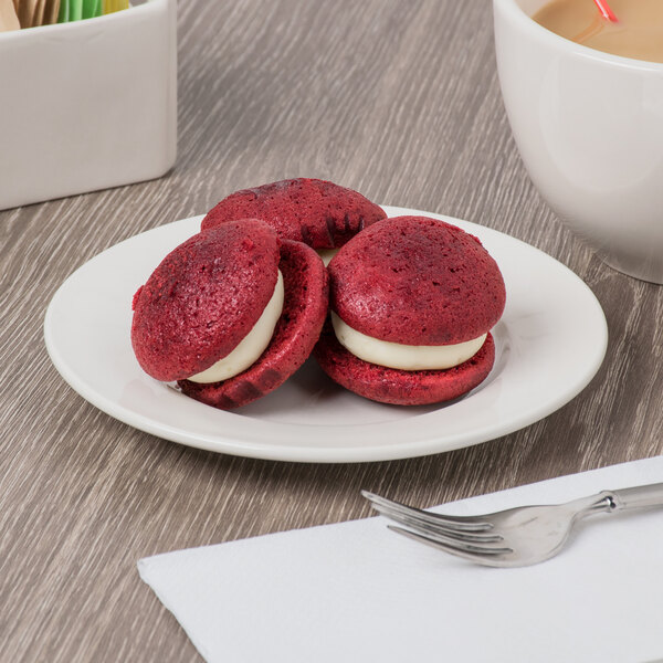 A Libbey ivory porcelain plate with red velvet cookies and a cup of coffee on it with a fork.