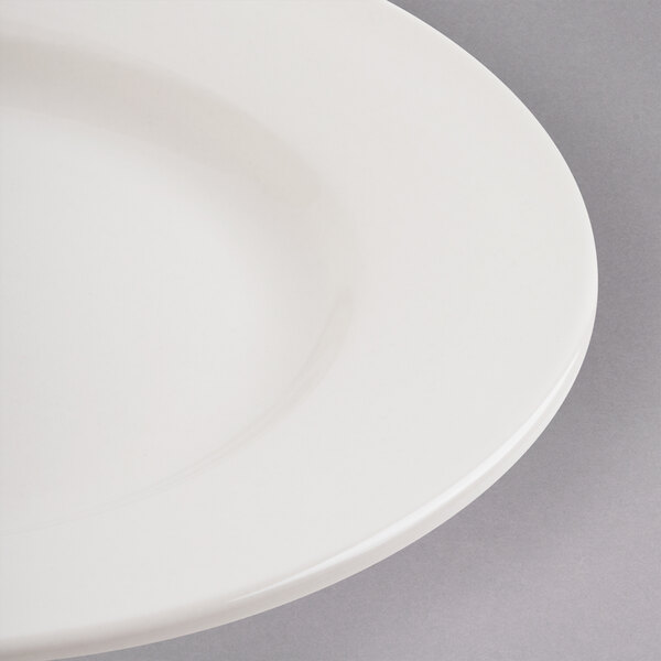 A close up of a Libbey ivory porcelain plate with a rim.