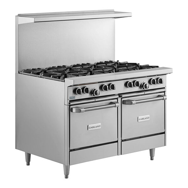 A large stainless steel Garland natural gas range with 8 burners and 2 space saver ovens.