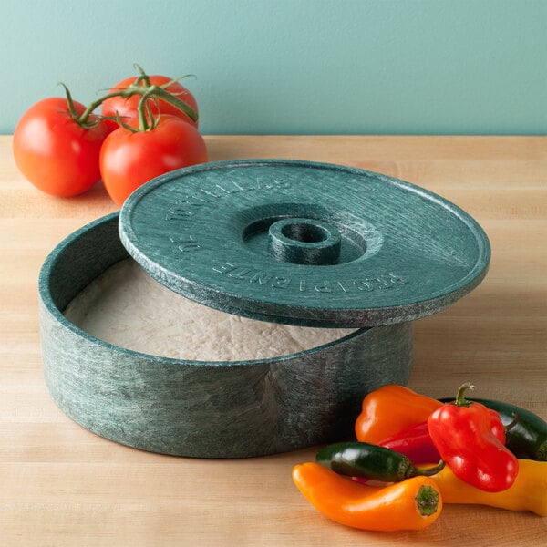 a round container with food in it next to tomatoes