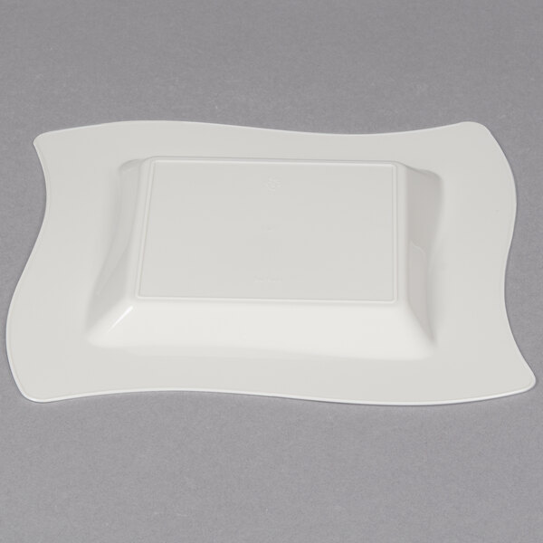 A white square Fineline plastic plate with a wavy edge.