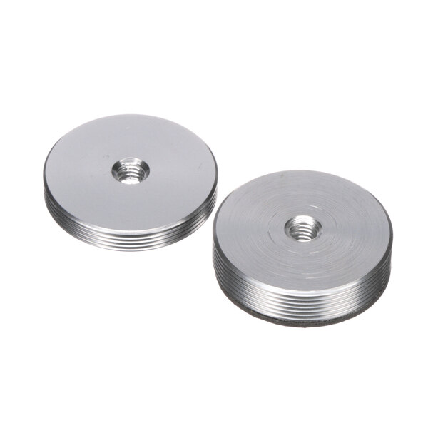 A close-up of a pair of round metal discs with stainless steel nuts on them.