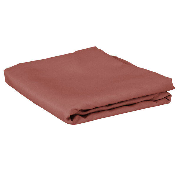 A folded mauve cloth table cover on a white background.