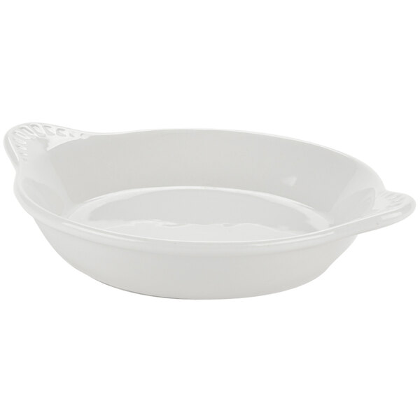 A Tuxton eggshell white china shirred egg dish with a handle.