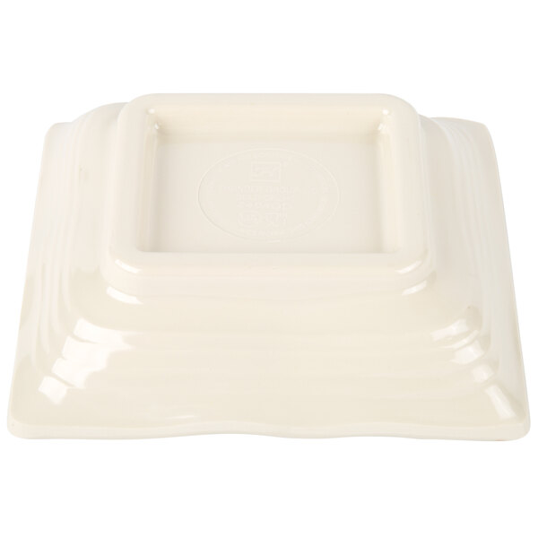 A white square Thunder Group sauce dish with a square center.