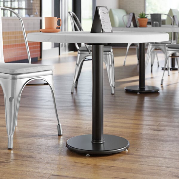 A Lancaster Table & Seating black cast iron table base in a restaurant dining area.