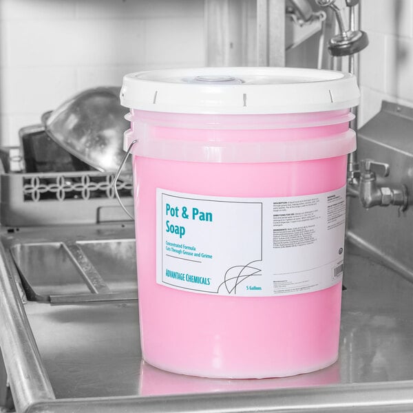 A white bucket of Advantage Chemicals concentrated pot and pan soap on a counter.