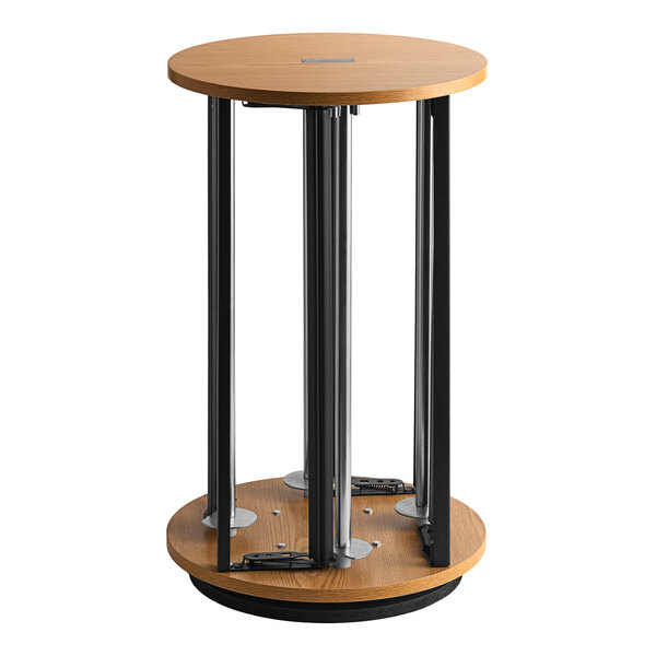 A round wooden table with a metal pole attached to it.
