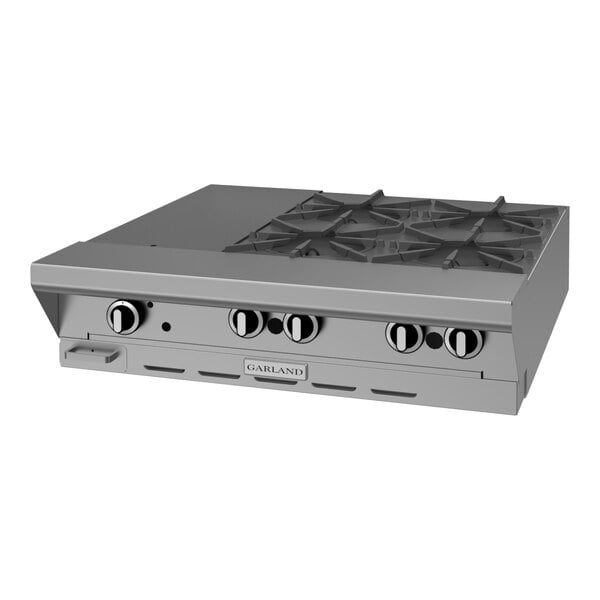 A stainless steel commercial 4-burner modular gas range top with control knobs and an even heat hot top.