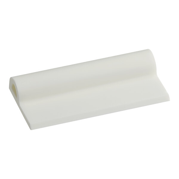 A white rectangular plastic lid scraper.