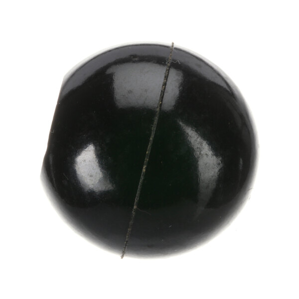 A close-up of a black and green glass bead with a crack in the middle.