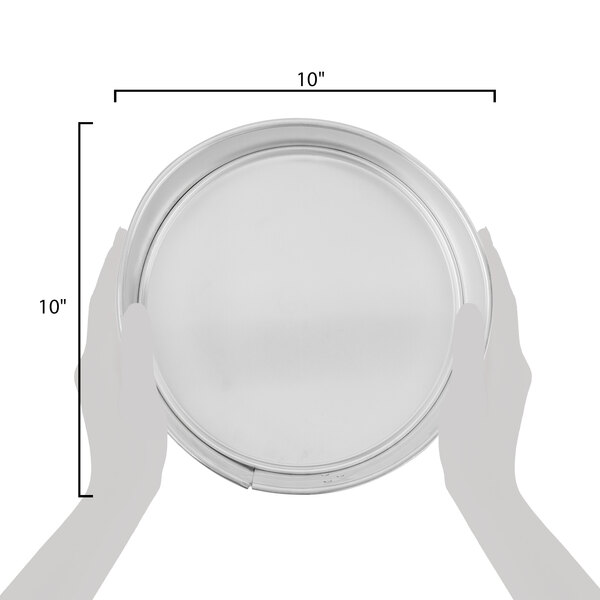 A hand using a Chicago Metallic aluminum springform cake pan to hold a round cake on a white plate.