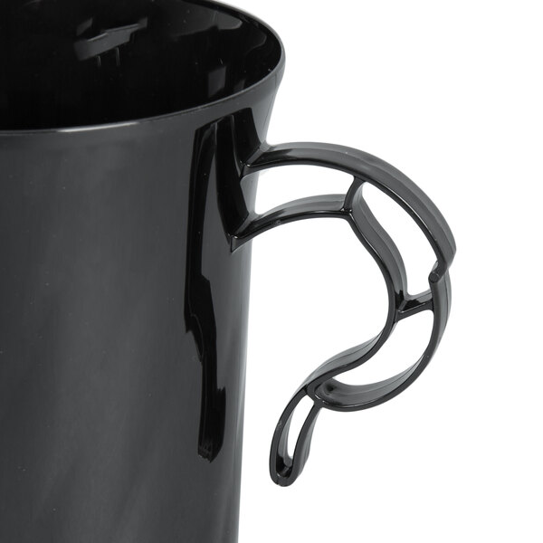 A close-up of a black WNA Comet plastic coffee cup with a handle.