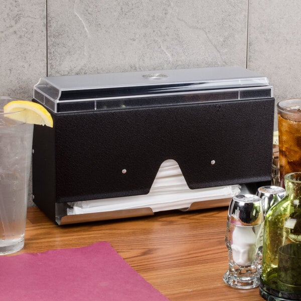 A black Vollrath Straw Boss dispenser on a counter in a pizza parlor.