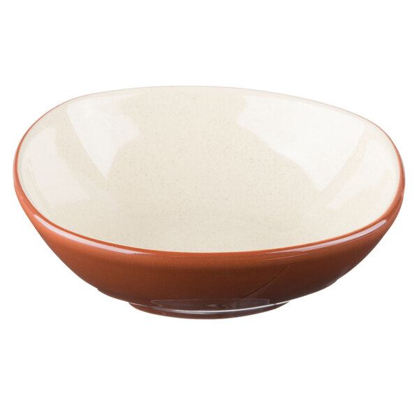 A close up of a Libbey Terracotta bowl with a white base and a brown rim.