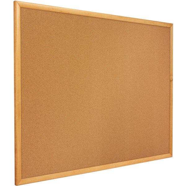 A Quartet cork board with a wooden frame.