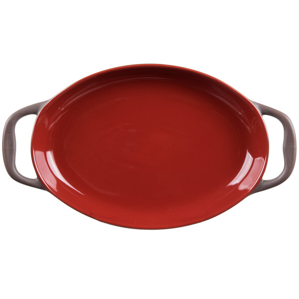 A red oval Libbey Coos Bay stoneware dish with two handles.