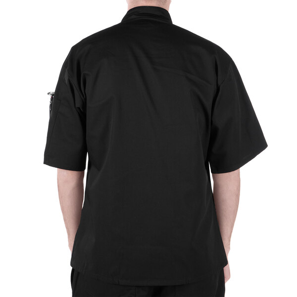 A person wearing a Mercer Culinary black chef's jacket with black buttons and pockets.