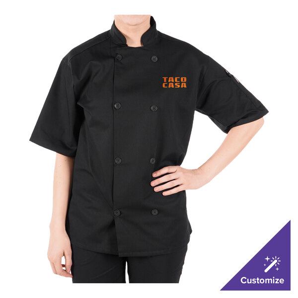A person wearing a black chef coat with an orange logo.