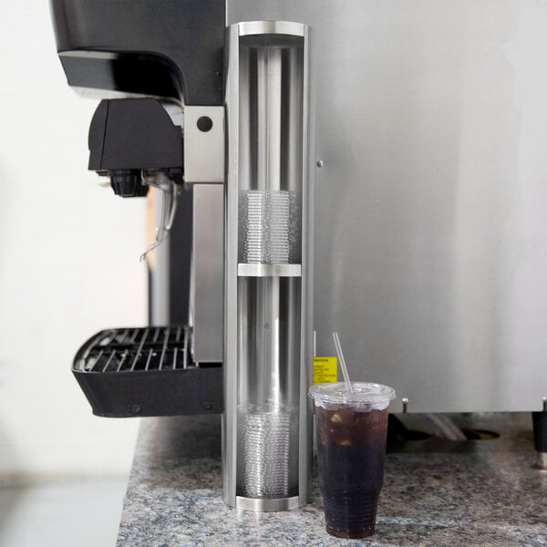 A Vollrath stainless steel lid holder on a counter near a coffee machine.