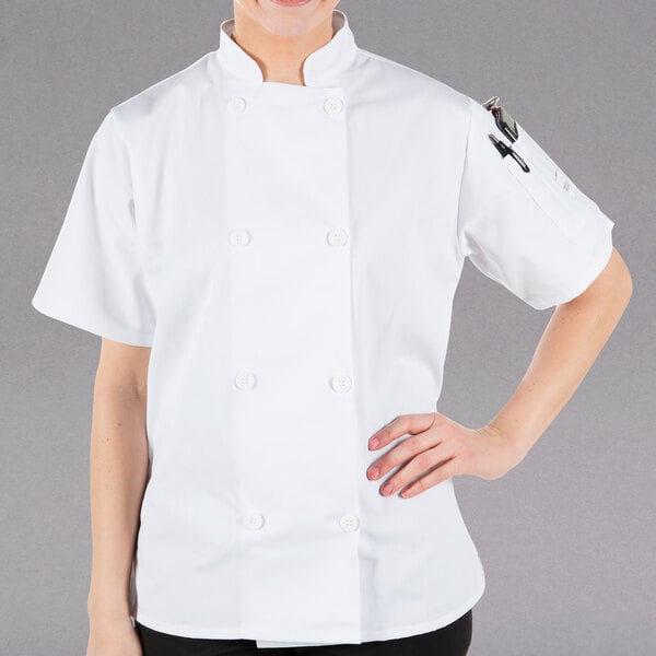 A woman wearing a white Mercer Culinary Millennia chef's coat.