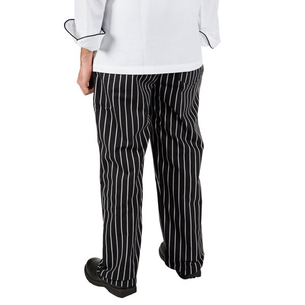 A person wearing Mercer Culinary black cook pants with white chalk stripes.