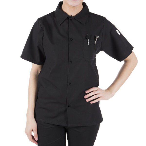 A woman wearing a Mercer Culinary Millennia black cook shirt.