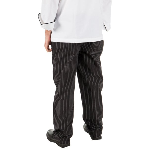 A person wearing Mercer Culinary pinstriped black cook pants.