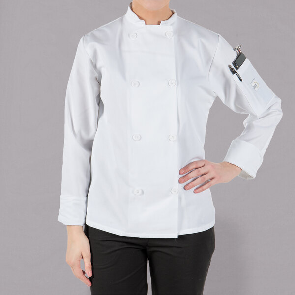 A woman wearing a white Mercer Culinary long sleeve chef jacket.