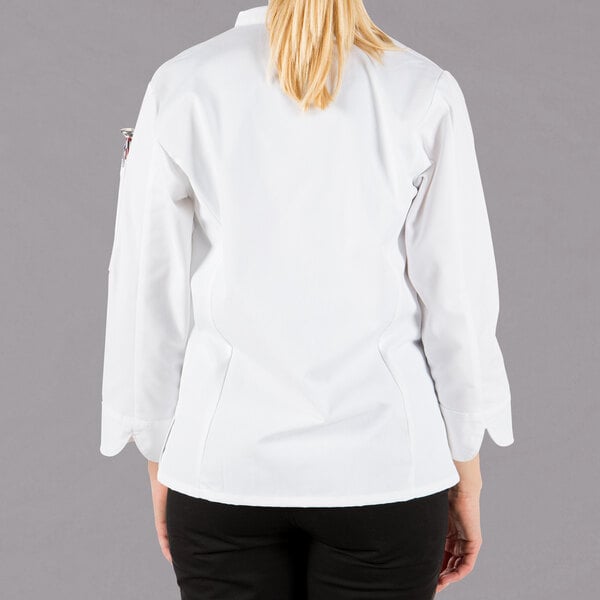 A woman wearing a white Mercer Culinary Millennia chef jacket with knot buttons.