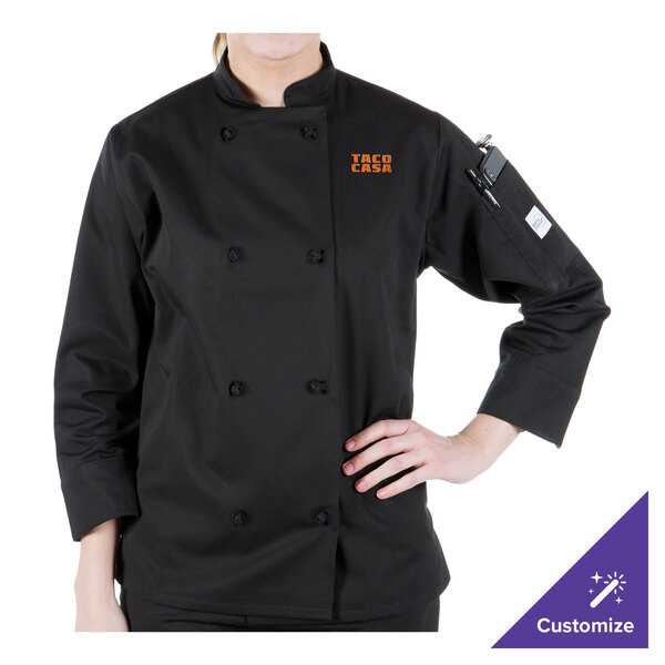 A woman wearing a black Mercer Culinary Millennia chef coat with a logo on the sleeve.